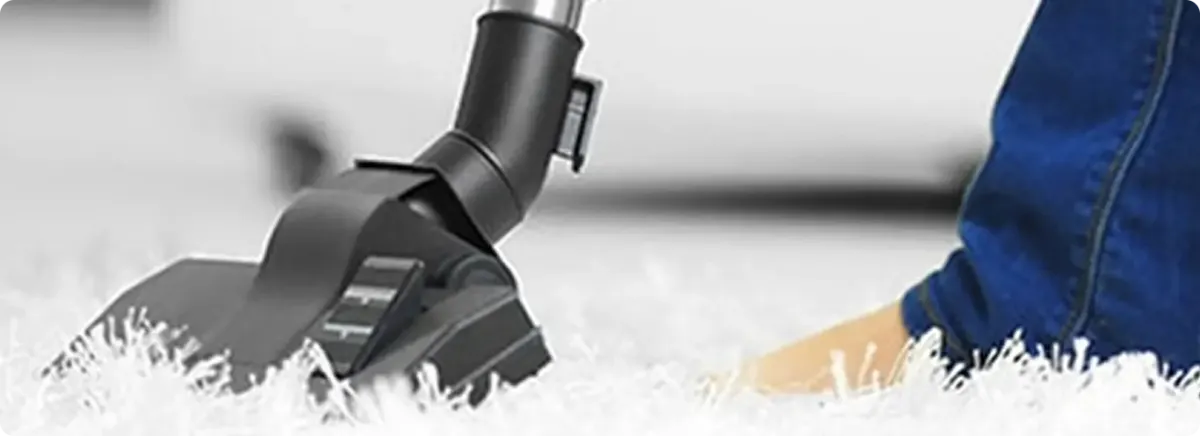 Close-up of a professional vacuuming a white carpet in Shawnee Mission.